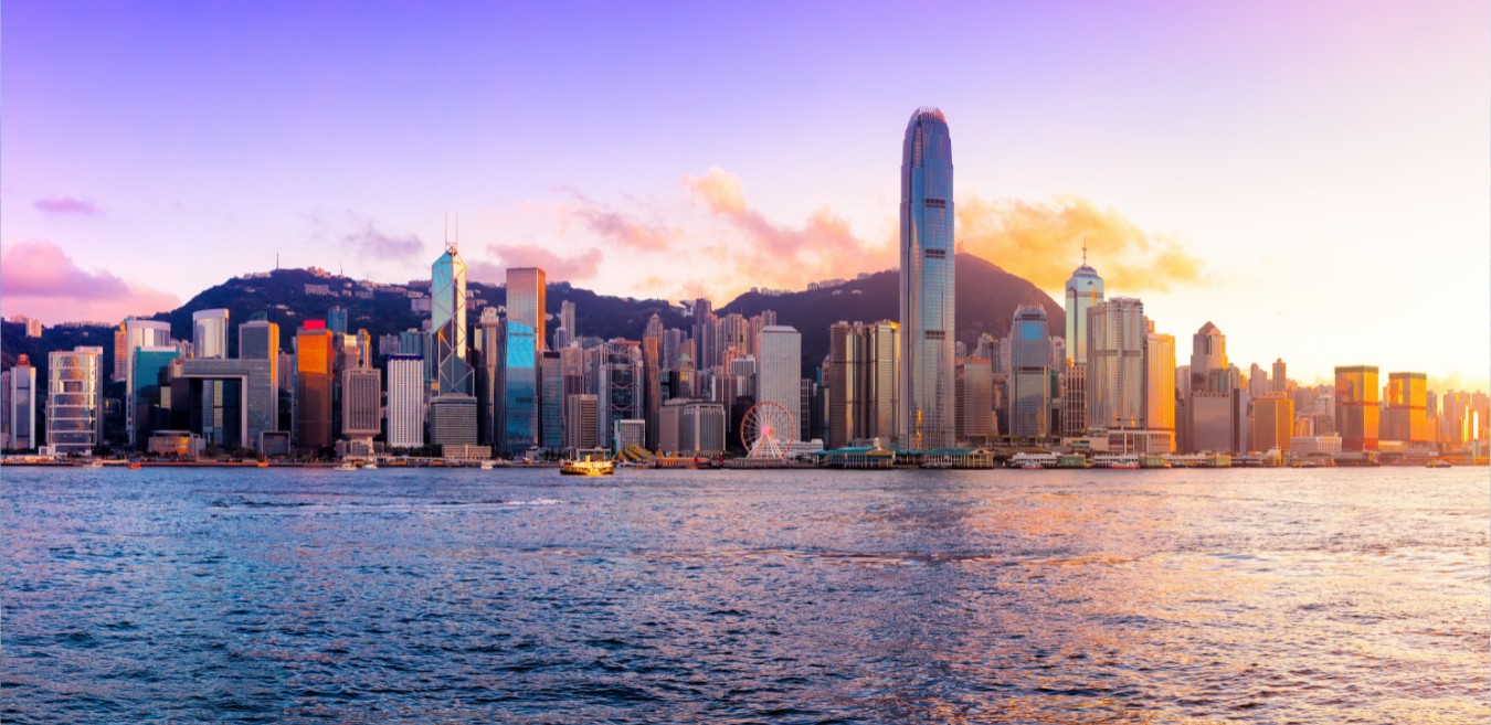 Hong Kong Island skyline across Victoria Harbour at sunset